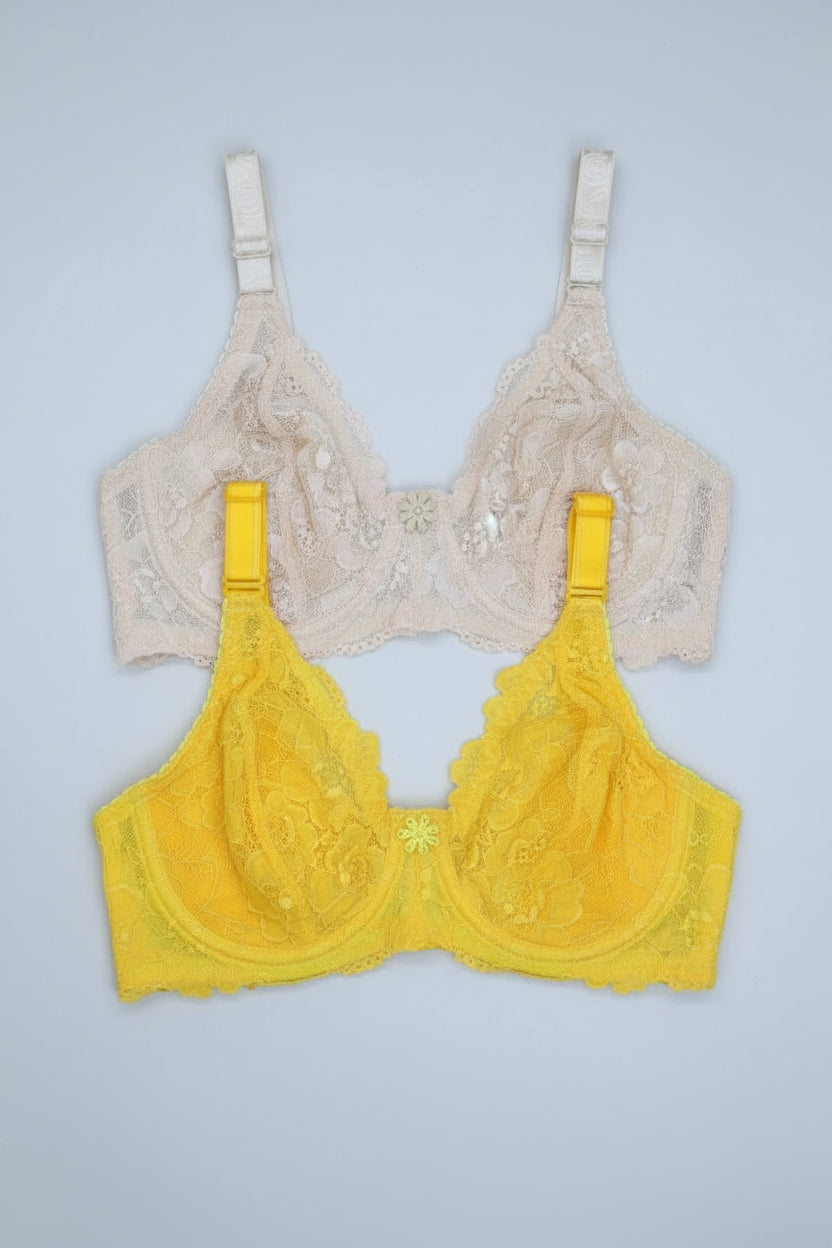 Yellow and beige lace bras on a gray background.